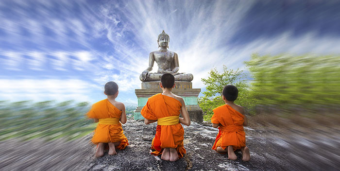 Novice Monk praying to the Buddha in Phrabuddhachay Temple, Saraburi, Thailand.